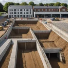 Construction site cutaway reveals foundations, drainage, utilities and compacted aggregate layers