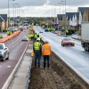 Photorealistic wide editorial hero image of a major UK town-centre highway improvement linked to a new development