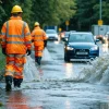 Civil engineers survey stormwater runoff across rain-soaked urban streets
